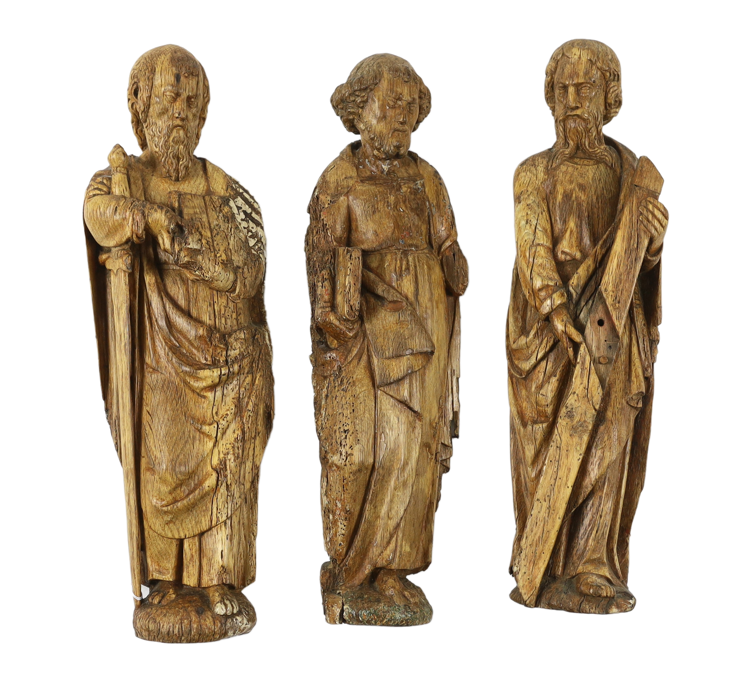 A set of three 18th century Continental carved wood figures of Saints, largest 17cm wide, 58cm high